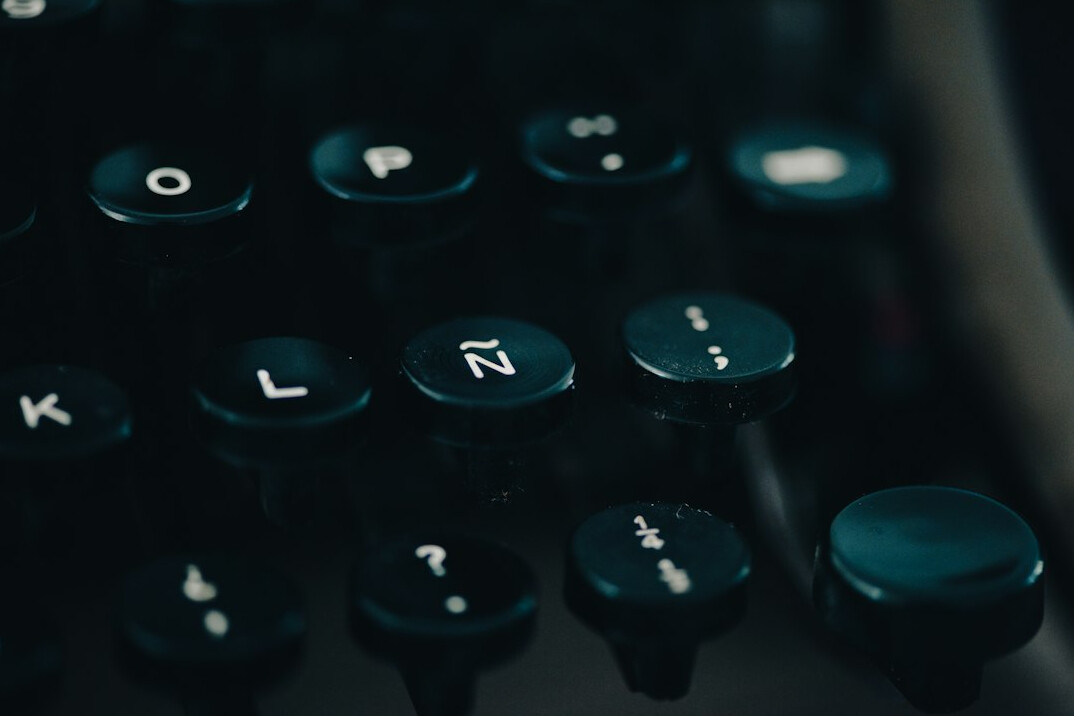 Close-up of hands typing code on a laptop keyboard