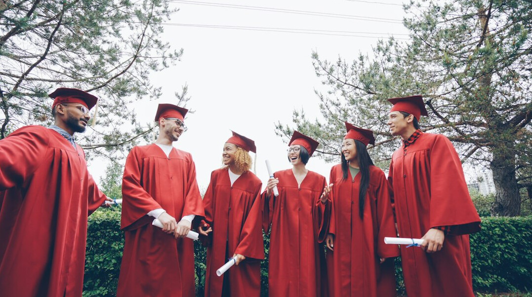 Group of young graduates celebrating together outdoors
