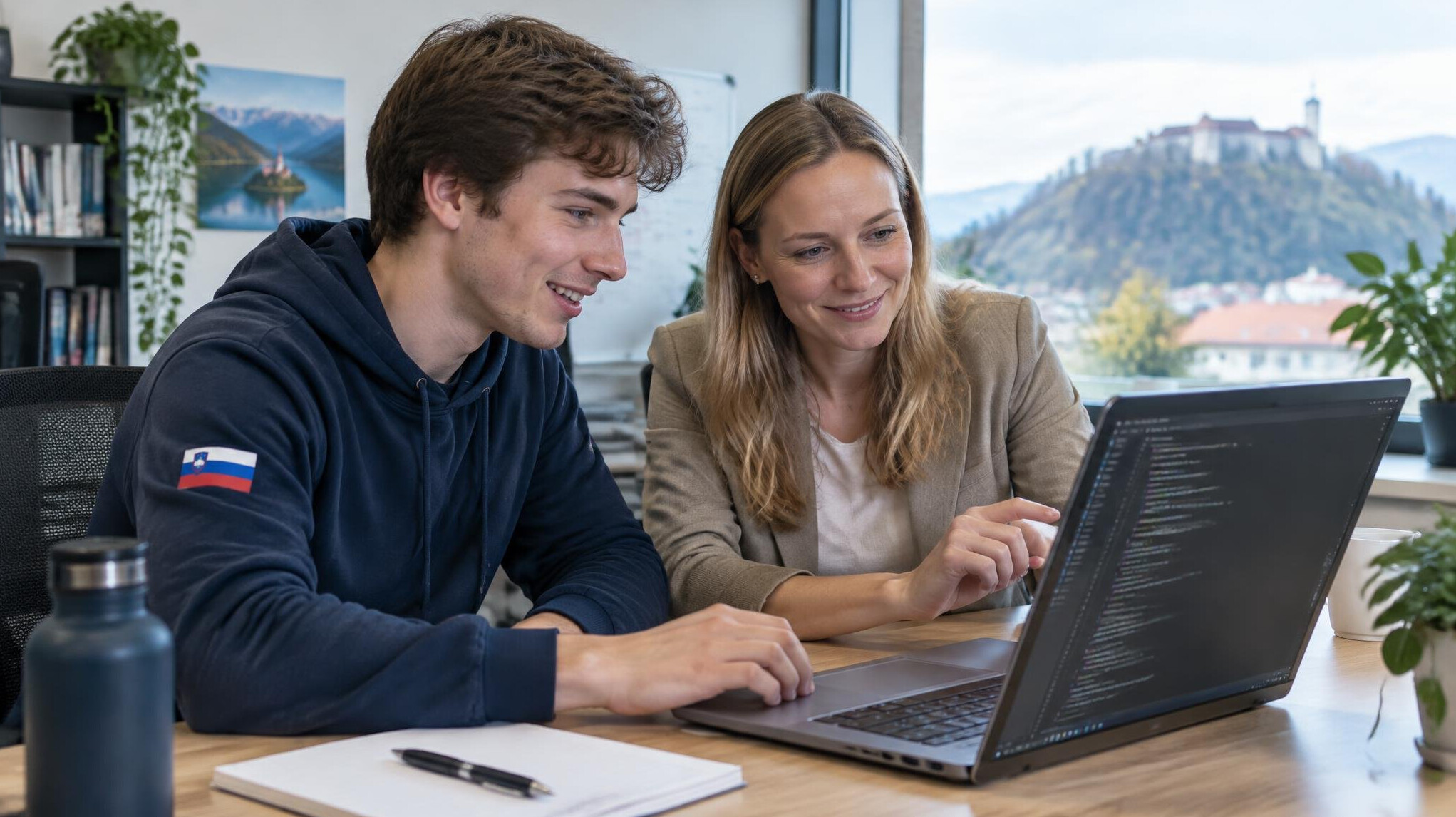 Student working on a coding project with a mentor at a shared desk